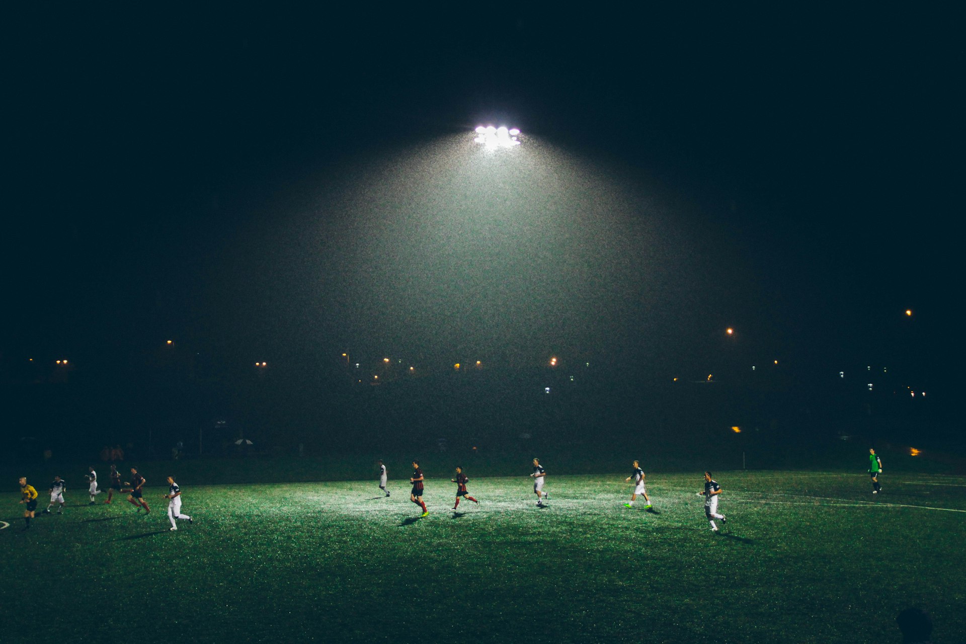 Vol veld tijdens een wedstrijd, met sponsoruitingen in beeld
